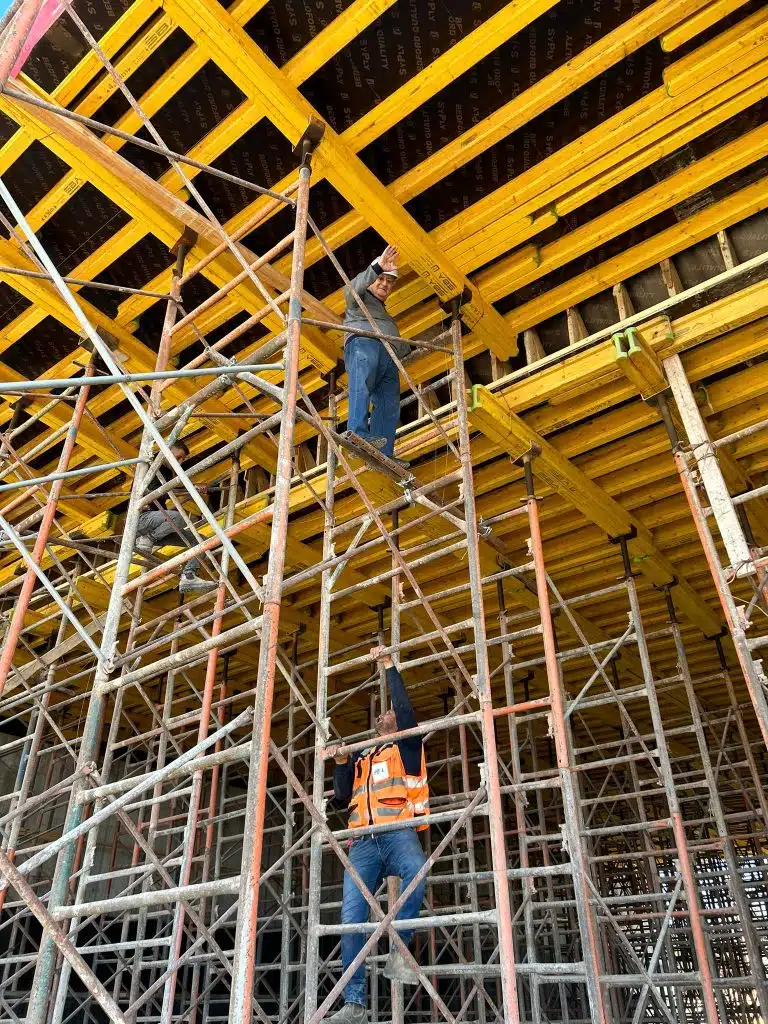 עובדים בין מגדלי תמיכה מתחת לתבנית תקרה