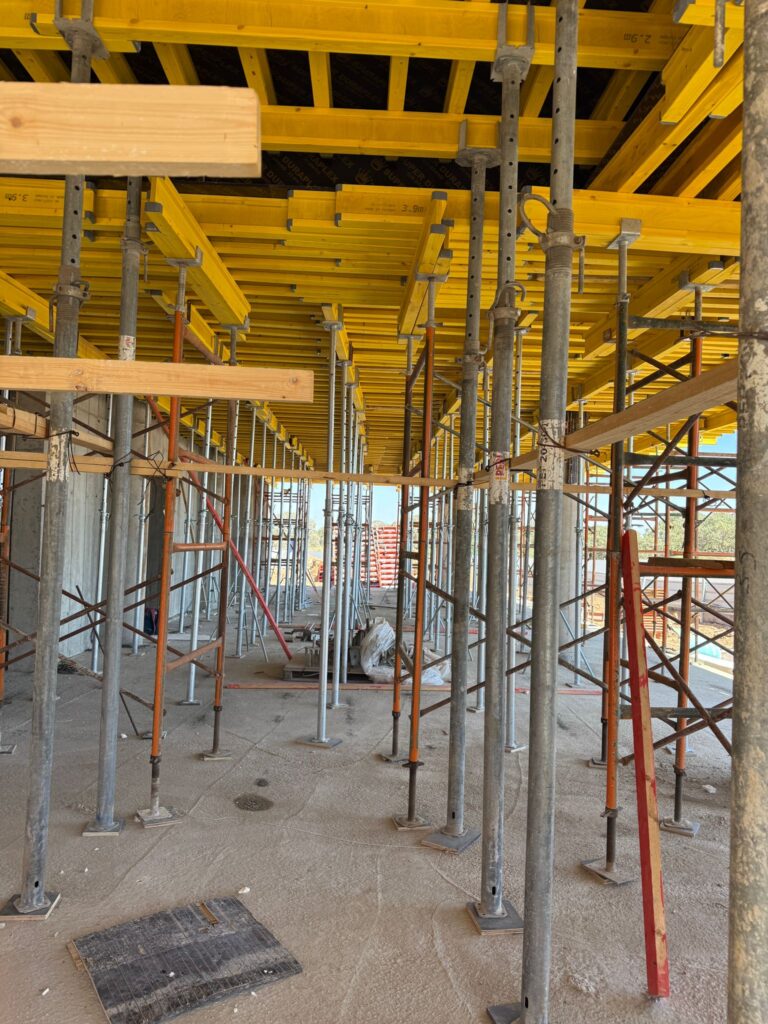 רגלי תמיכה ומגדלים מתחת לתקרה עם קורות עץ צהובות